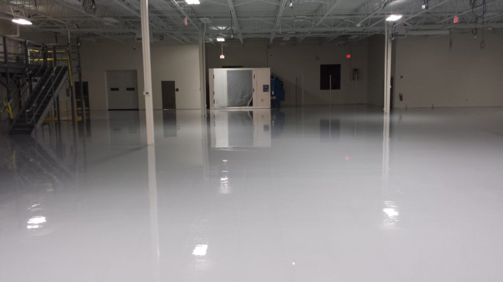 A solid white epoxy flooring at a manufacturing facility shows a clean, glossy, industrial-grade surface