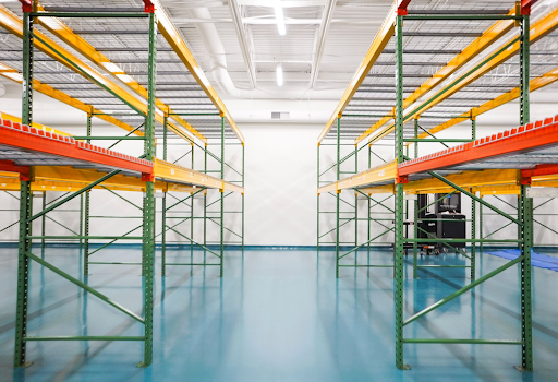 A life sciences facility featuring brightly colored shelving and blue, slip-resistant flooring is designed to meet DCOF standards, ensuring worker safety.